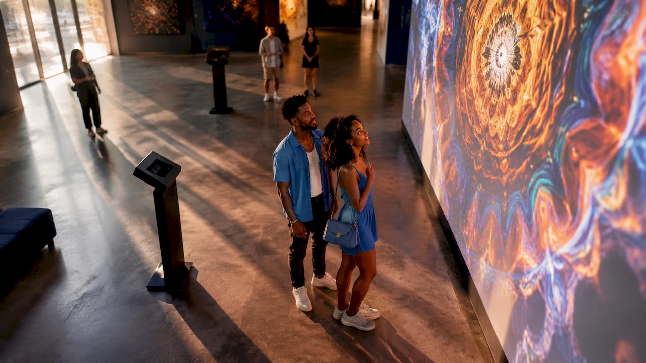Visitors exploring immersive digital art museum gallery